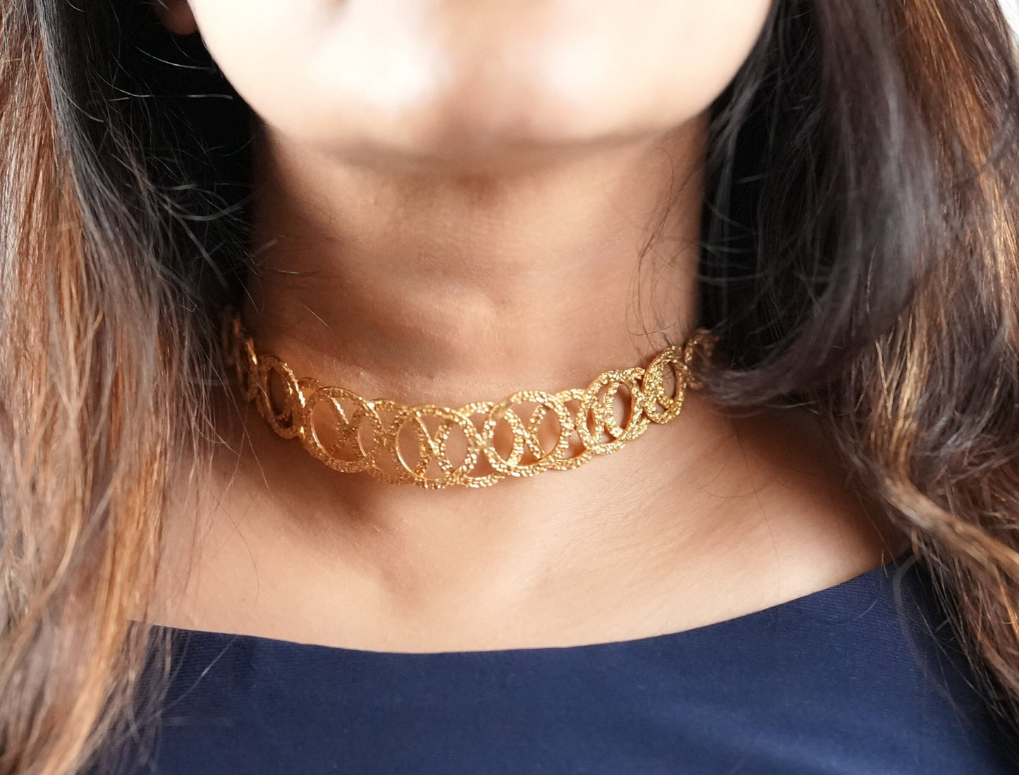 Model wearing a handcrafted gold-toned choker necklace with interlocking oval loops – statement semi-fine jewelry by Adiva Jewelry