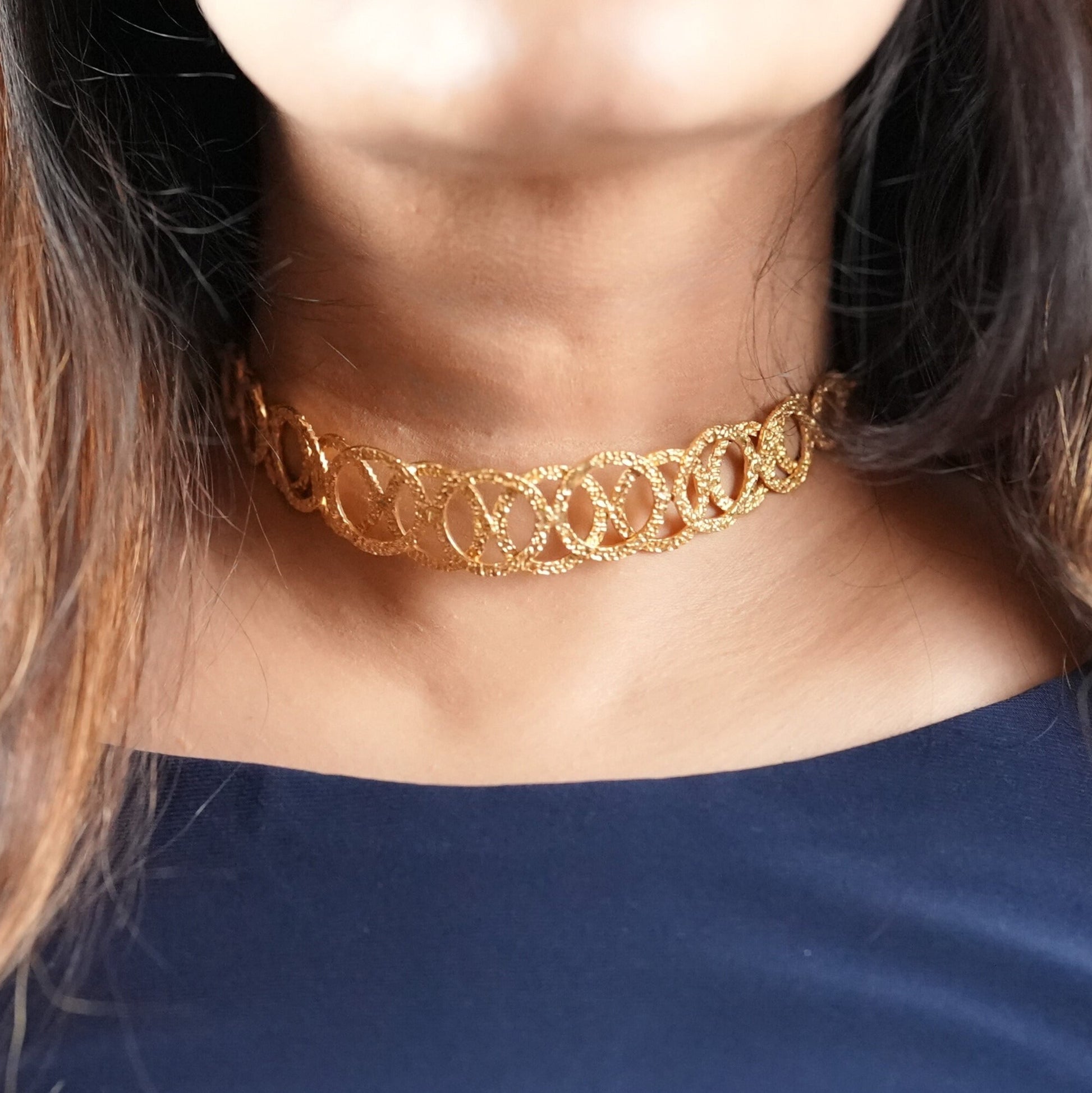 Woman in her 30s wearing a handcrafted gold-toned choker necklace with interlocking oval loops – statement semi-fine jewelry by Adiva Jewelry