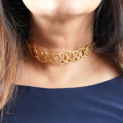 Woman in her 30s wearing a handcrafted gold-toned choker necklace with interlocking oval loops – statement semi-fine jewelry by Adiva Jewelry