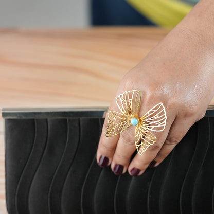 Elegant brass butterfly ring with a pop of turquoise, styled with a black clutch — a chic statement piece from Adiva Jewelry for brunches, date nights, and standout everyday style