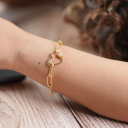 Lady working in a corporate office on a laptop wearing a heart shaped bracelet that is in silver with gold plating - handcrafted by Adiva Jewelry