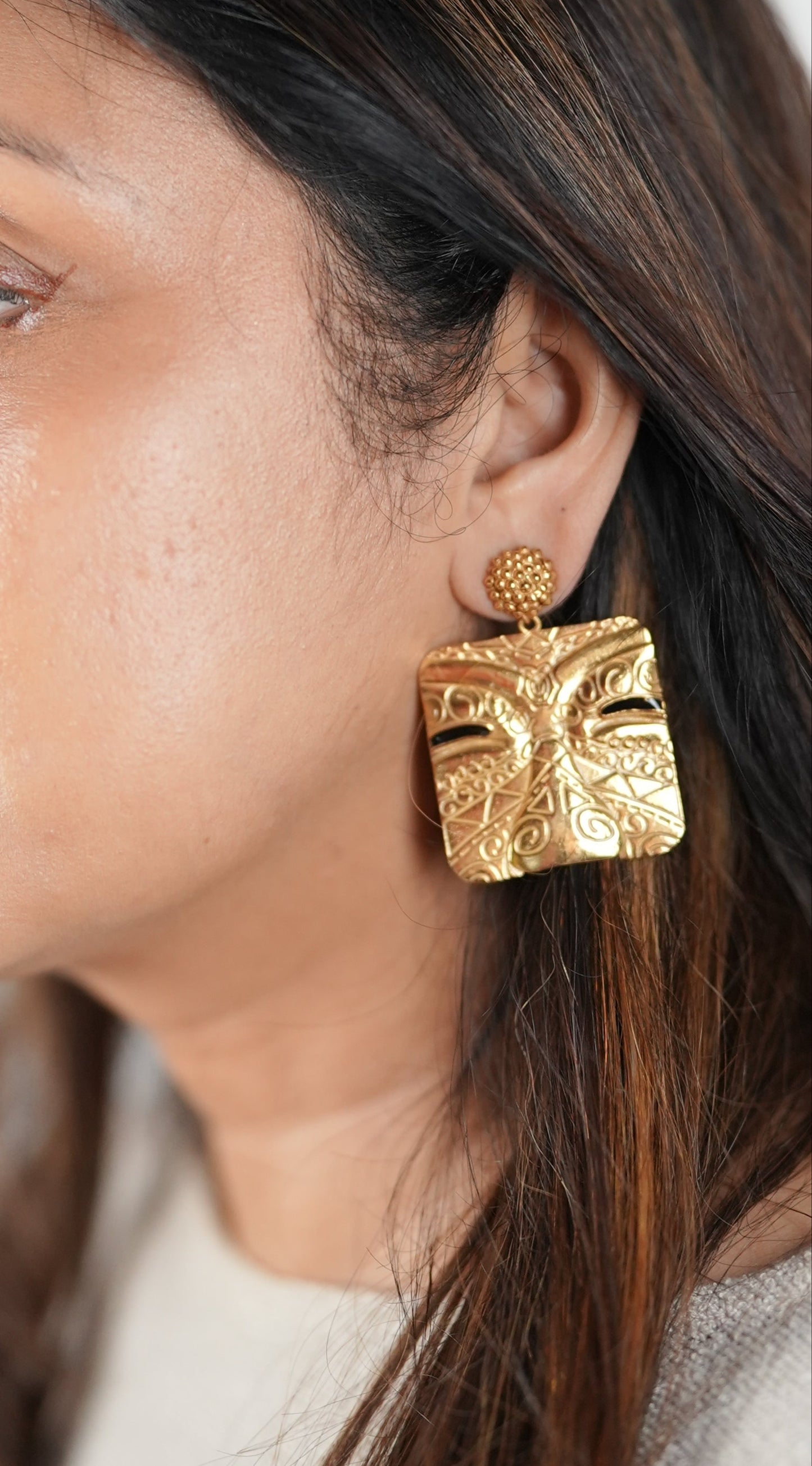Intricately carved gold-toned statement earrings in a tribal face motif – handcrafted using skin-safe brass by Adiva Jewelry
