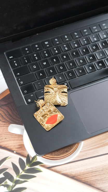 Gold-toned statement earrings with  a tribal face and lips motif – handcrafted using skin-safe brass by Adiva Jewelry