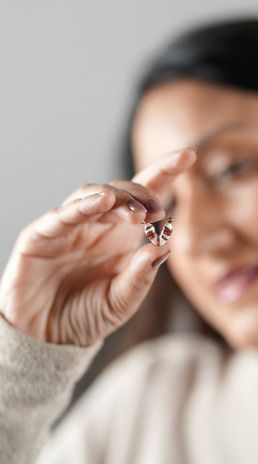 A girl holding a candy pink earring in her hand that is cute and trendy - by Adiva Jewelry