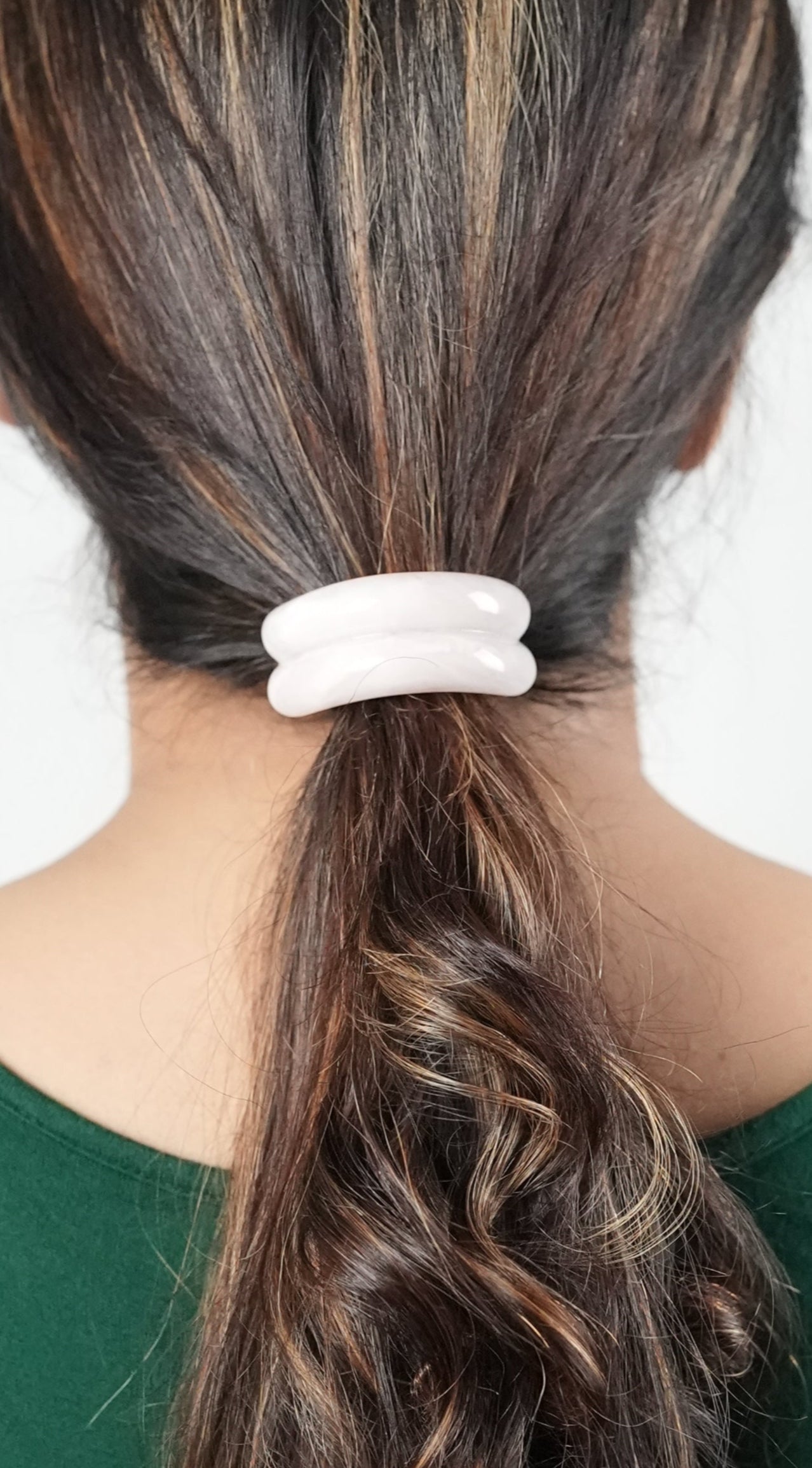 A girl with long hair wearing a hair tie in pink color , trendy  hair accessory for the fashion forward woman- by Adiva Jewelry