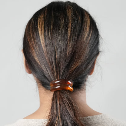 A girl with long hair wearing a hair tie in brown color , perfect hair accessory for the fashion conscious woman- by Adiva Jewelry