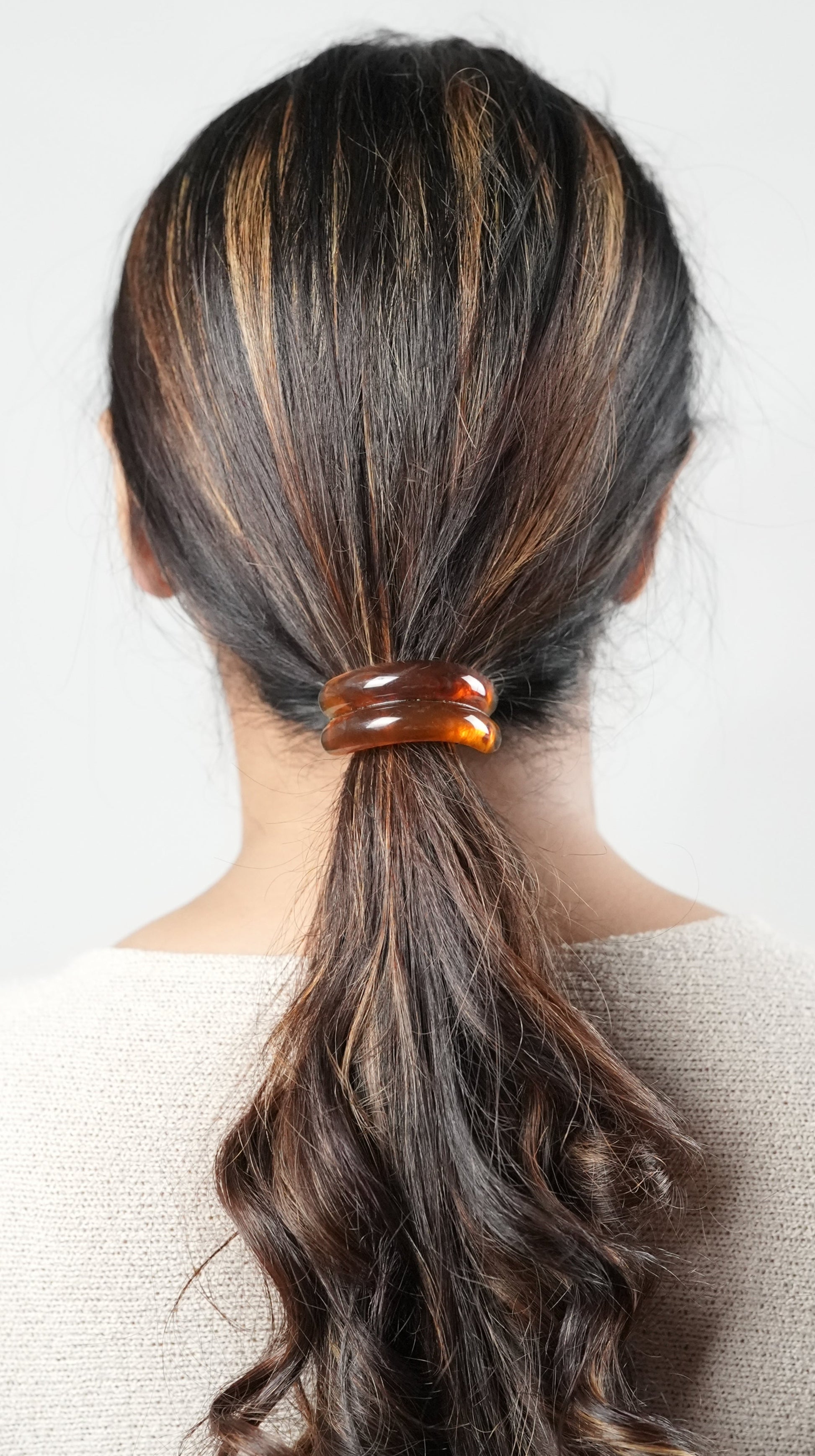 A girl with long hair wearing a hair tie in brown color , perfect hair accessory for the fashion conscious woman- by Adiva Jewelry