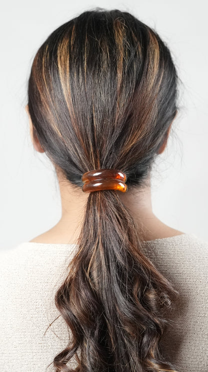A girl with long hair wearing a hair tie in brown color , perfect hair accessory for the fashion conscious woman- by Adiva Jewelry