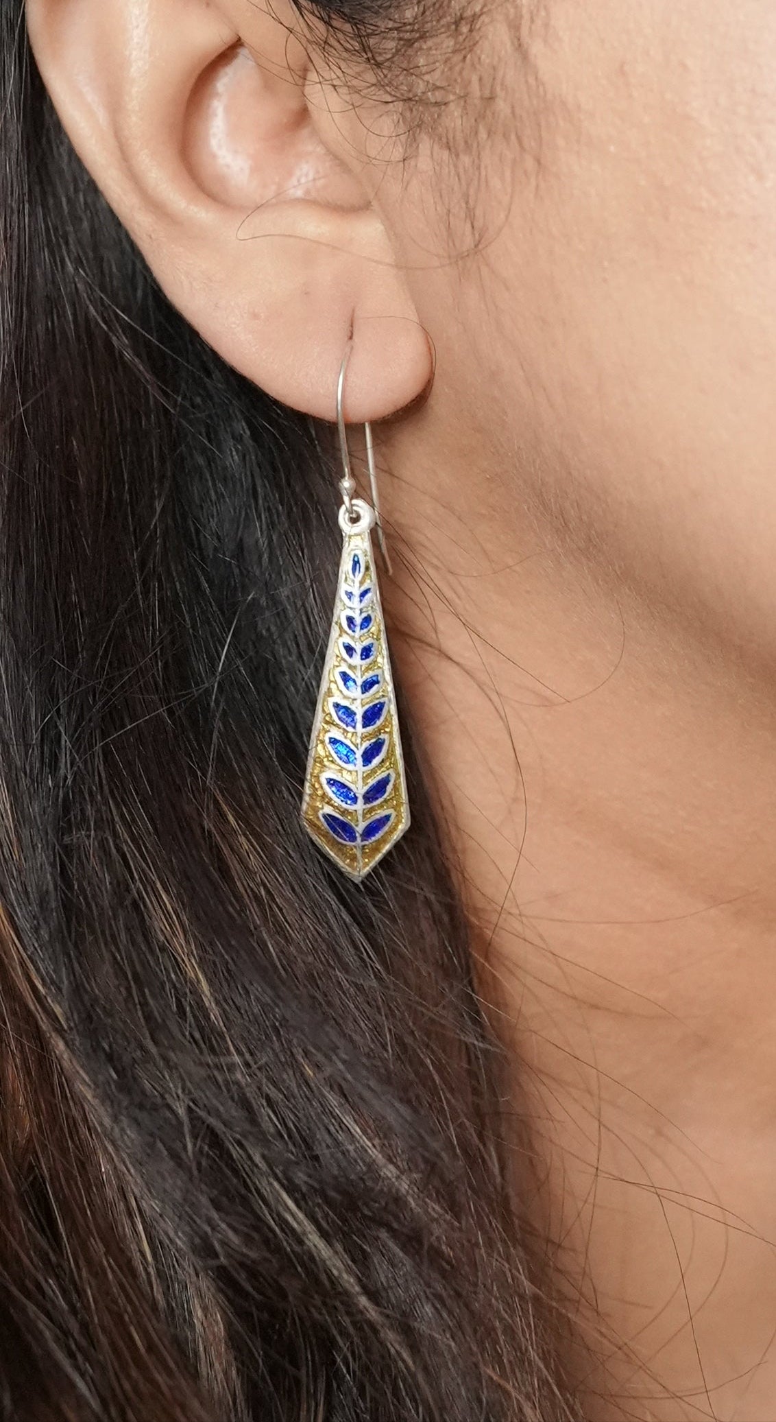 Close-up of a woman's ear with an earring with enamel work by Adiva Jewelry