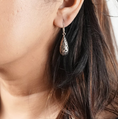 Close-up of a woman wearing an oxidized silver earring with her daily wear outfit. Earring is from Adiva Jewelry