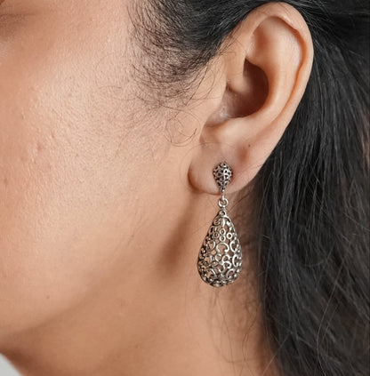 Woman wearing a dangler earring in oxidized silver by Adiva Jewelry that can be worn with both Indian and western outfits