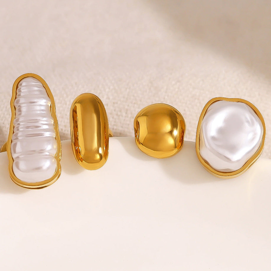 Elegant gold-tone statement rings with abstract pearl and molten metal designs, styled on hand for Adiva Jewelry — a modern lifestyle jewelry brand celebrating artistic fashion.