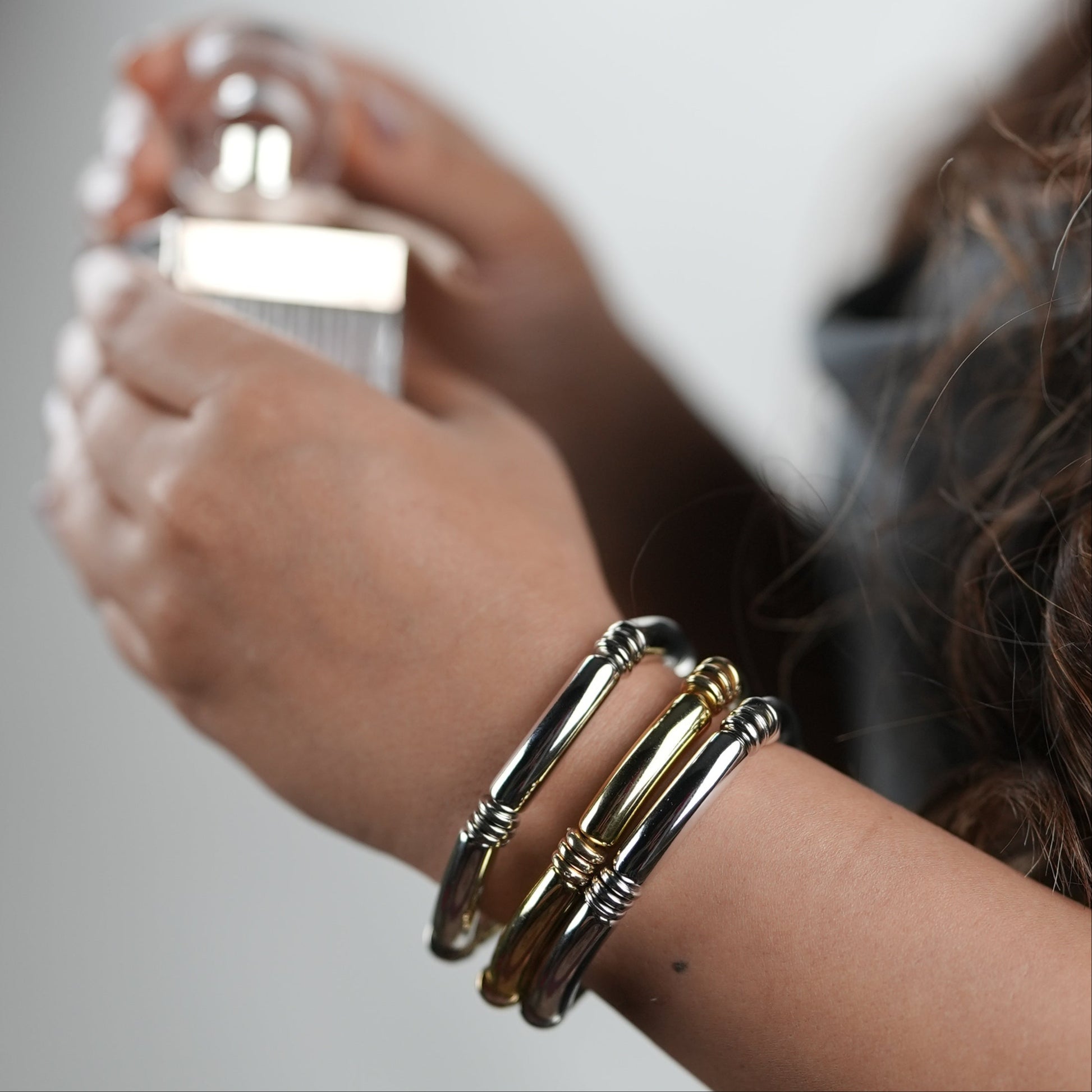 Woman in her late 20s getting ready to go out for a date night and wearing a three bangle set of Adiva Jewelry